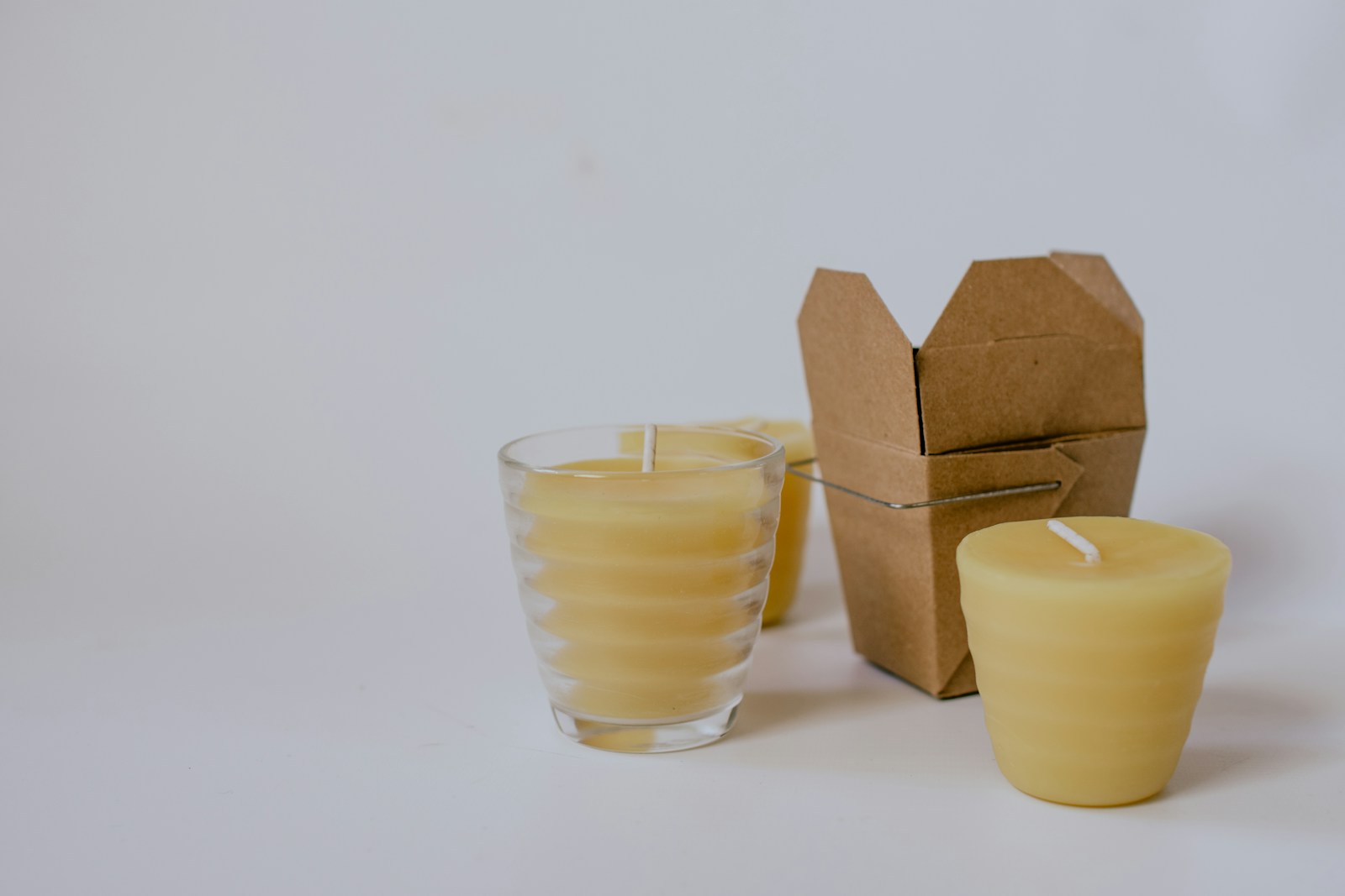 Honey-colored beeswax candles with kraft packaging