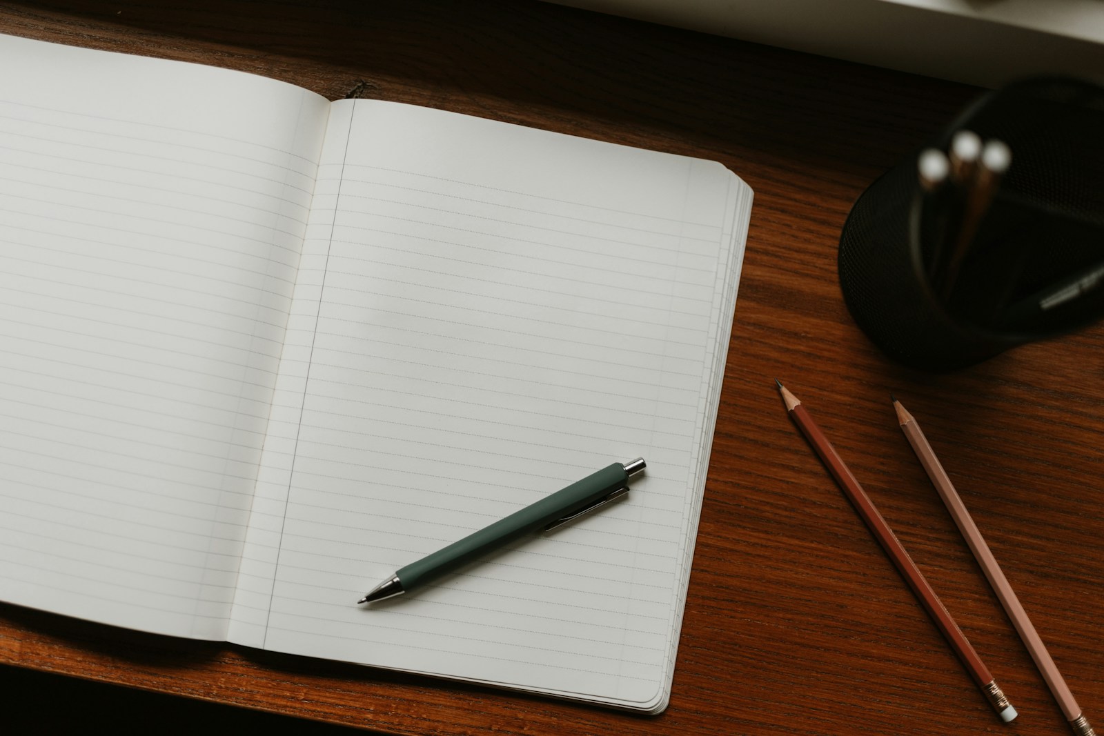 Open lined notebook with pen on a walnut desk