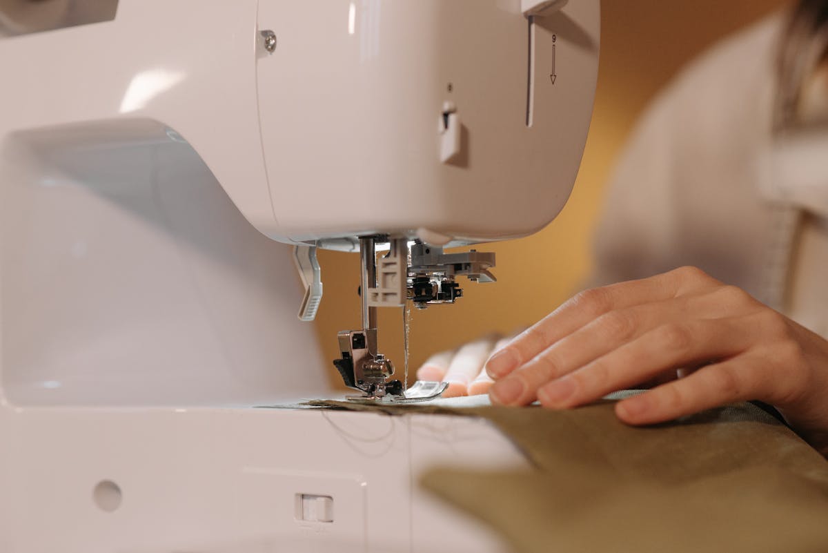 Close detail of a sewing machine stitching cream linen